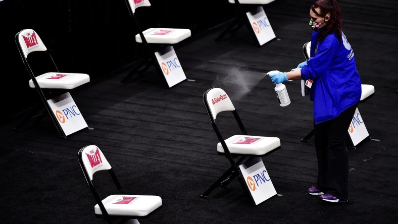 Mar 5, 2021; St. Louis, Missouri, USA; Staff spray and wipe down chairs near the court after the quarterfinals game of the Missouri Valley Conference Tournament between the Drake Bulldogs and the Northern Iowa Panthers at Enterprise Center was cancelled.  Mandatory Credit: Jeff Curry-USA TODAY Sports