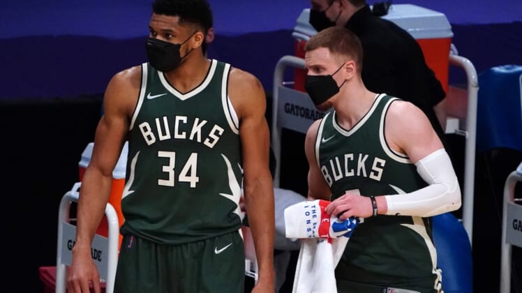 Mar 31, 2021; Los Angeles, California, USA; Milwaukee Bucks forward Giannis Antetokounmpo (34) and guard Donte DiVincenzo (0) watch from the bench wearing face masks  in the second halfagainst the Los Angeles Lakers  at Staples Center. Mandatory Credit: Kirby Lee-USA TODAY Sports