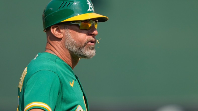 Aug 8, 2021; Oakland, California, USA;  Oakland Athletics third base coach Mark Kotsay (7) spits out sunflower seeds during the eighth inning against the Texas Rangers at RingCentral Coliseum. Mandatory Credit: Stan Szeto-USA TODAY Sports