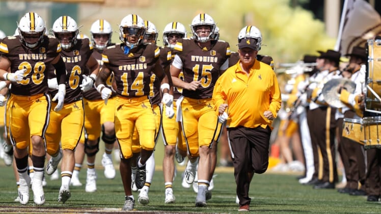 Sep 18, 2021; Laramie, Wyoming, USA; Wyoming Cowboys head coach Craig Bohl leads his team onto the field before game against the Ball State Cardinals at Jonah Field at War Memorial Stadium. Mandatory Credit: Troy Babbitt-USA TODAY Sports