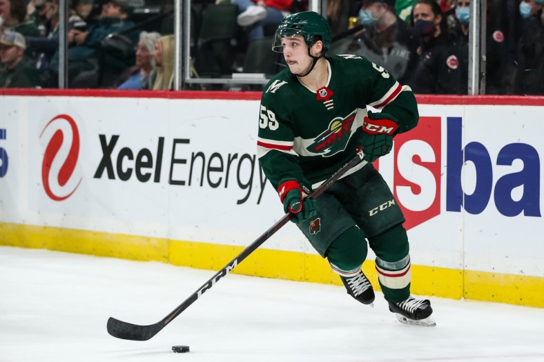 Oct 7, 2021; Saint Paul, Minnesota, USA; Minnesota Wild defenseman Calen Addison (59) skates with the puck against the Chicago Blackhawks in the first period at Xcel Energy Center. Mandatory Credit: David Berding-USA TODAY Sports