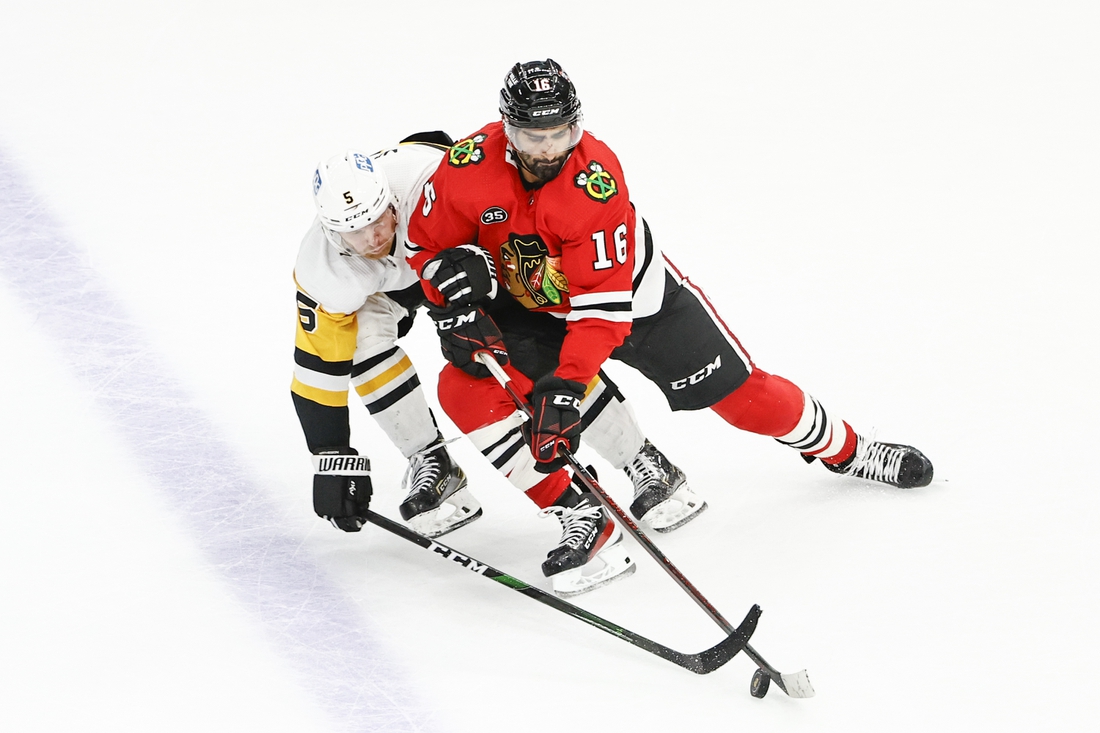 Nov 9, 2021; Chicago, Illinois, USA; Chicago Blackhawks center Jujhar Khaira (16) battles for the puck with Pittsburgh Penguins defenseman Zach Trotman (5) during the third period at United Center. Mandatory Credit: Kamil Krzaczynski-USA TODAY Sports