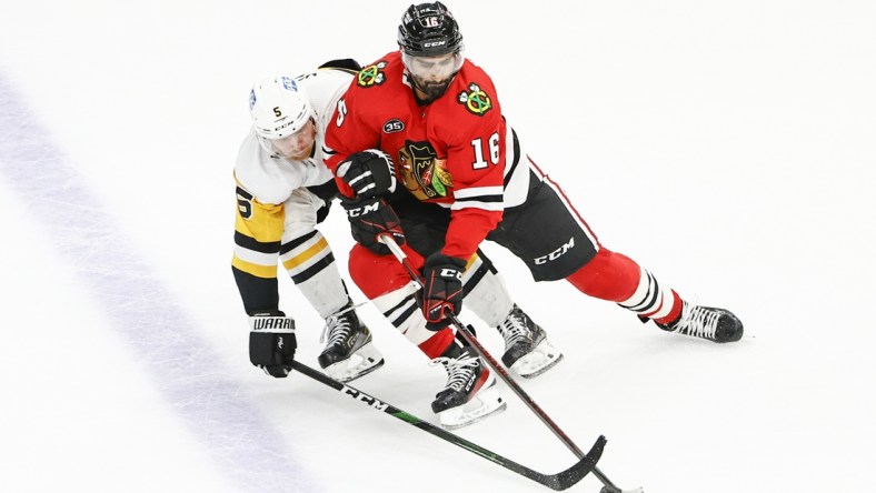 Nov 9, 2021; Chicago, Illinois, USA; Chicago Blackhawks center Jujhar Khaira (16) battles for the puck with Pittsburgh Penguins defenseman Zach Trotman (5) during the third period at United Center. Mandatory Credit: Kamil Krzaczynski-USA TODAY Sports