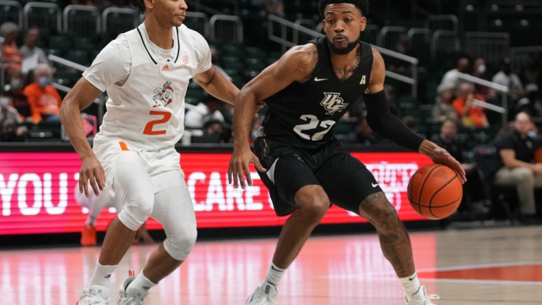 Nov 13, 2021; Coral Gables, Florida, USA; UCF Knights guard Darin Green Jr. (22) controls the ball around Miami Hurricanes guard Isaiah Wong (2) during the first half at Watsco Center. Mandatory Credit: Jasen Vinlove-USA TODAY Sports