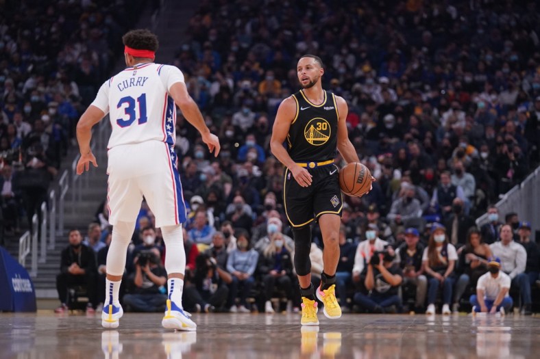 Nov 24, 2021; San Francisco, California, USA; Golden State Warriors guard Stephen Curry (30) dribbles the ball next to Philadelphia 76ers guard Seth Curry (31) in the first quarter at the Chase Center. Mandatory Credit: Cary Edmondson-USA TODAY Sports