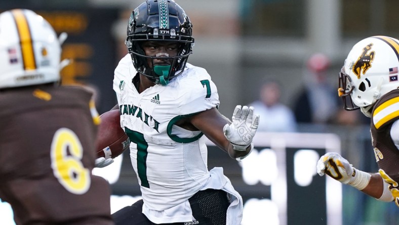 Nov 27, 2021; Laramie, Wyoming, USA; Hawaii Rainbow Warriors running back Calvin Turner Jr. (7) runs against the Wyoming Cowboys during the fourth quarter at Jonah Field at War Memorial Stadium. Mandatory Credit: Troy Babbitt-USA TODAY Sports