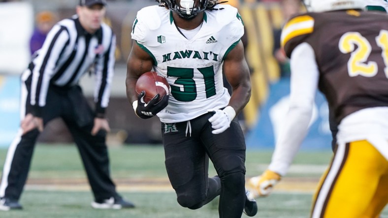 Nov 27, 2021; Laramie, Wyoming, USA; Hawaii Rainbow Warriors running back Dedrick Parson (31) runs against the Wyoming Cowboys during the fourth quarter at Jonah Field at War Memorial Stadium. Mandatory Credit: Troy Babbitt-USA TODAY Sports