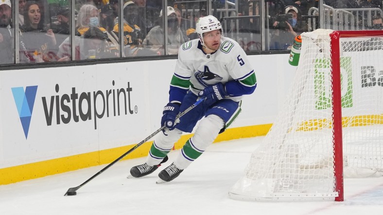 Nov 28, 2021; Boston, Massachusetts, USA; Vancouver Canucks defenseman Tucker Poolman (5) skates with the puck against the Boston Bruins during the second period at TD Garden. Mandatory Credit: Gregory Fisher-USA TODAY Sports