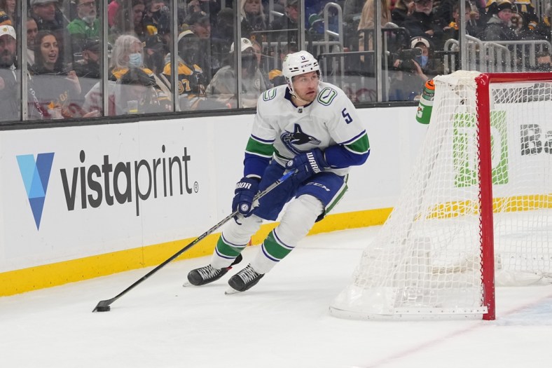 Nov 28, 2021; Boston, Massachusetts, USA; Vancouver Canucks defenseman Tucker Poolman (5) skates with the puck against the Boston Bruins during the second period at TD Garden. Mandatory Credit: Gregory Fisher-USA TODAY Sports