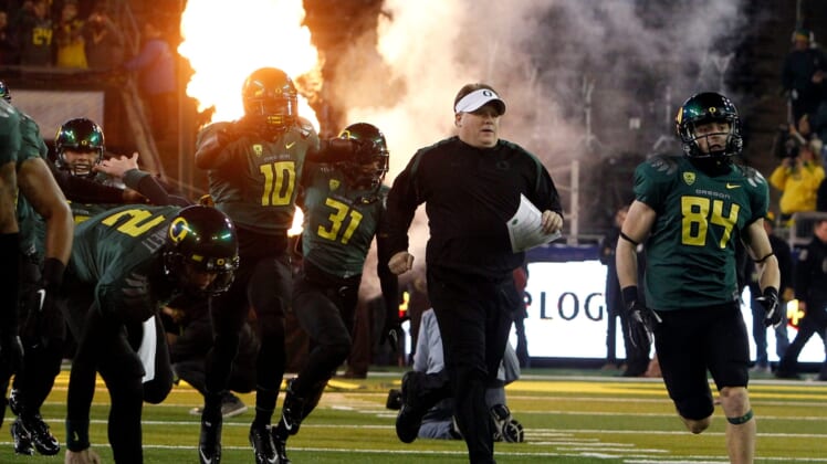 Head Coach Chip Kelly, center, and the team take the field for the first Pac-12 Championship game at Autzen in 2011.Eug 113021 Pac12 Champs 01