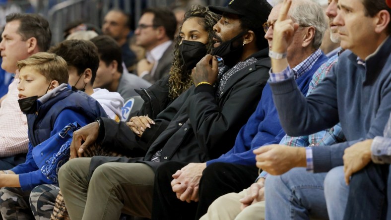 Dec 1, 2021; Newark, New Jersey, USA; Brooklyn Nets guard Kyrie Irving (center, black hat) watches action during the second half of the game between the Seton Hall Pirates and the Wagner Seahawks at Prudential Center. Mandatory Credit: Vincent Carchietta-USA TODAY Sports