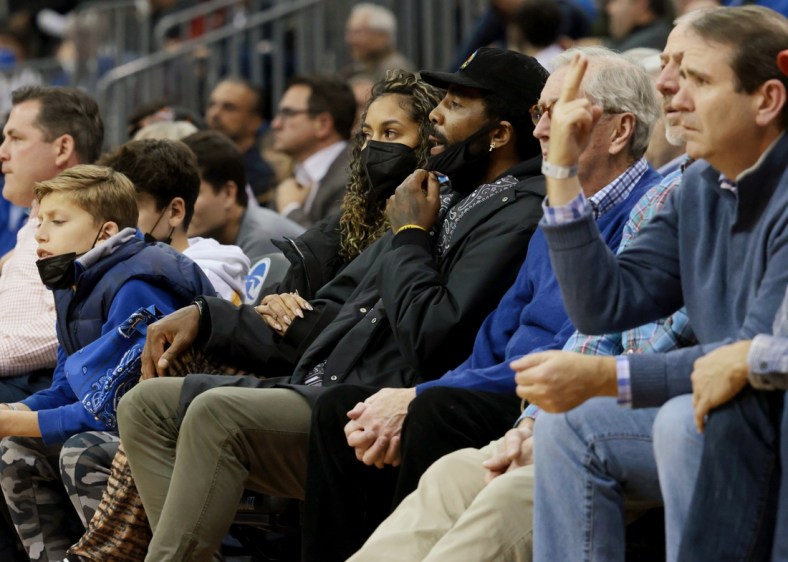 Dec 1, 2021; Newark, New Jersey, USA; Brooklyn Nets guard Kyrie Irving (center, black hat) watches action during the second half of the game between the Seton Hall Pirates and the Wagner Seahawks at Prudential Center. Mandatory Credit: Vincent Carchietta-USA TODAY Sports