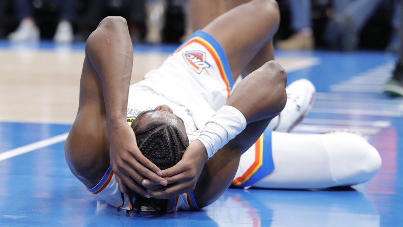 Dec 1, 2021; Oklahoma City, Oklahoma, USA; Oklahoma City Thunder guard Shai Gilgeous-Alexander (2) grabs his head after hitting the floor following a foul during the second half against the Houston Rockets at Paycom Center. Mandatory Credit: Alonzo Adams-USA TODAY Sports