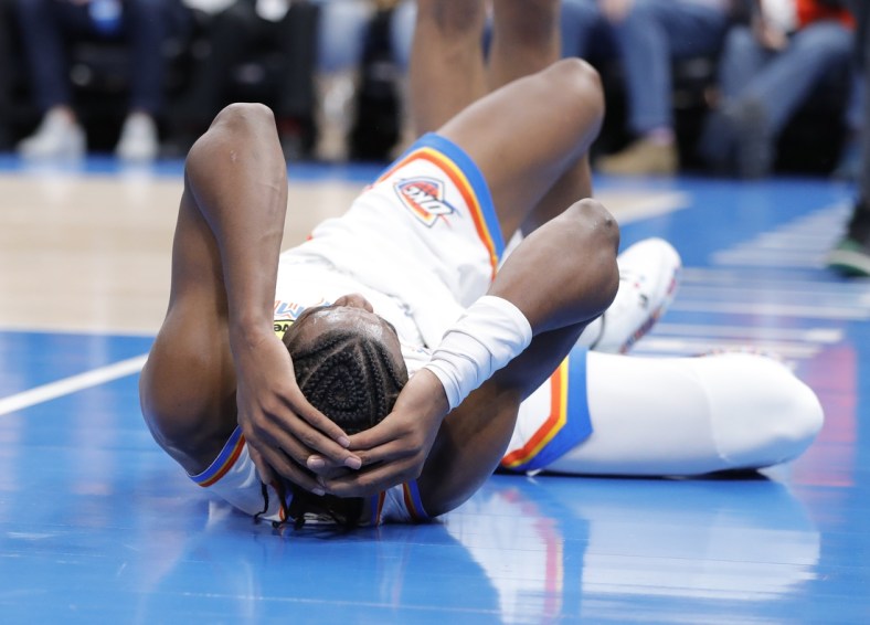 Dec 1, 2021; Oklahoma City, Oklahoma, USA; Oklahoma City Thunder guard Shai Gilgeous-Alexander (2) grabs his head after hitting the floor following a foul during the second half against the Houston Rockets at Paycom Center. Mandatory Credit: Alonzo Adams-USA TODAY Sports