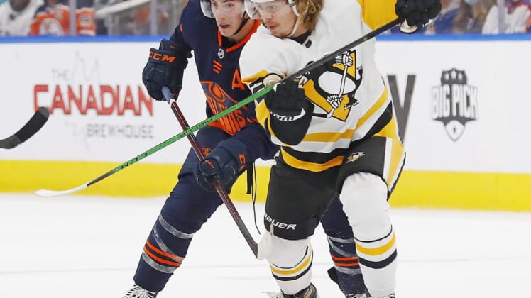 Dec 1, 2021; Edmonton, Alberta, CAN; Pittsburgh Penguins forward Kasperi Kapanen (42) and Edmonton Oilers forward Ryan Nugent-Hopkins (93) battle for a loose puck during the first period at Rogers Place. Mandatory Credit: Perry Nelson-USA TODAY Sports