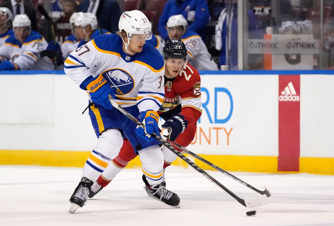 Dec 2, 2021; Sunrise, Florida, USA; Buffalo Sabres center Casey Mittelstadt (37) controls the puck away from Florida Panthers center Eetu Luostarinen (27) during the first period at FLA Live Arena. Mandatory Credit: Jasen Vinlove-USA TODAY Sports