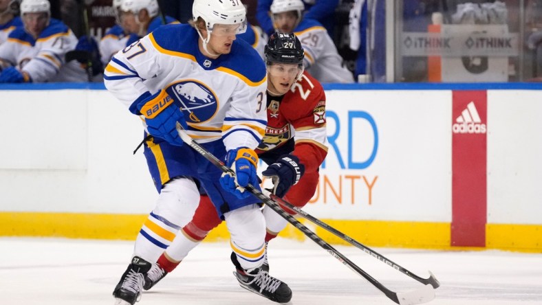 Dec 2, 2021; Sunrise, Florida, USA; Buffalo Sabres center Casey Mittelstadt (37) controls the puck away from Florida Panthers center Eetu Luostarinen (27) during the first period at FLA Live Arena. Mandatory Credit: Jasen Vinlove-USA TODAY Sports