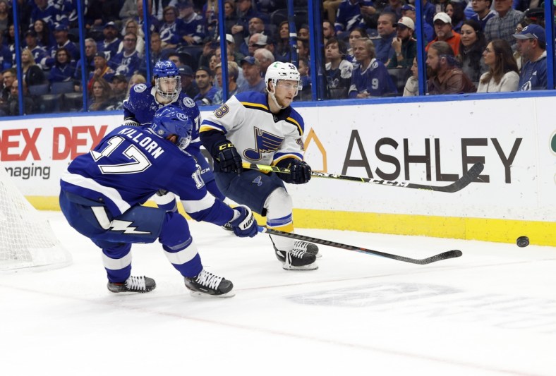 Dec 2, 2021; Tampa, Florida, USA; St. Louis Blues defenseman Scott Perunovich (48) passes the puck as Tampa Bay Lightning left wing Alex Killorn (17) defends during the first period at Amalie Arena. Mandatory Credit: Kim Klement-USA TODAY Sports