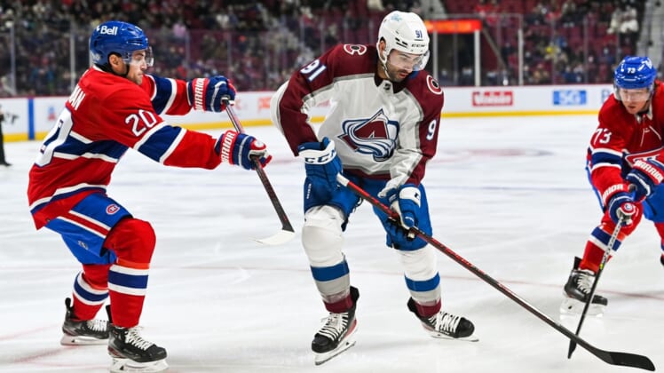 Dec 2, 2021; Montreal, Quebec, CAN; Colorado Avalanche center Nazem Kadri (91) plays the puck against Montreal Canadiens defenceman Chris Wideman (20) during the first period at Bell Centre. Mandatory Credit: David Kirouac-USA TODAY Sports