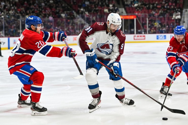 Dec 2, 2021; Montreal, Quebec, CAN; Colorado Avalanche center Nazem Kadri (91) plays the puck against Montreal Canadiens defenceman Chris Wideman (20) during the first period at Bell Centre. Mandatory Credit: David Kirouac-USA TODAY Sports