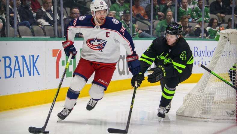 Dec 2, 2021; Dallas, Texas, USA; Dallas Stars defenseman Miro Heiskanen (4) defends against Columbus Blue Jackets center Boone Jenner (38) during the first period at the  American Airlines Center. Mandatory Credit: Jerome Miron-USA TODAY Sports