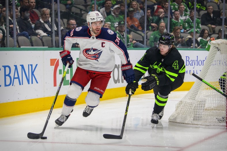 Dec 2, 2021; Dallas, Texas, USA; Dallas Stars defenseman Miro Heiskanen (4) defends against Columbus Blue Jackets center Boone Jenner (38) during the first period at the  American Airlines Center. Mandatory Credit: Jerome Miron-USA TODAY Sports