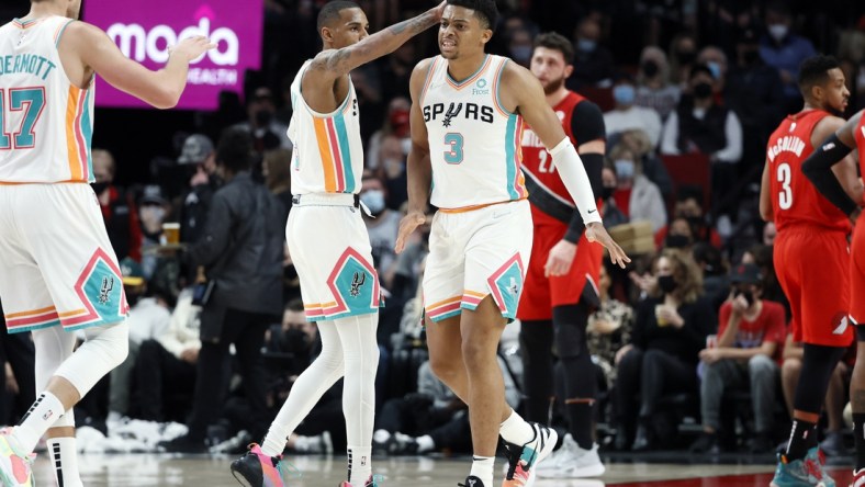 Dec 2, 2021; Portland, Oregon, USA; cSan Antonio Spurs small forward Keldon Johnson (3) celebrates a basket and a foul with teammate Dejounte Murray (5) during the first half against the Portland Trail Blazers at Moda Center. Mandatory Credit: Soobum Im-USA TODAY Sports