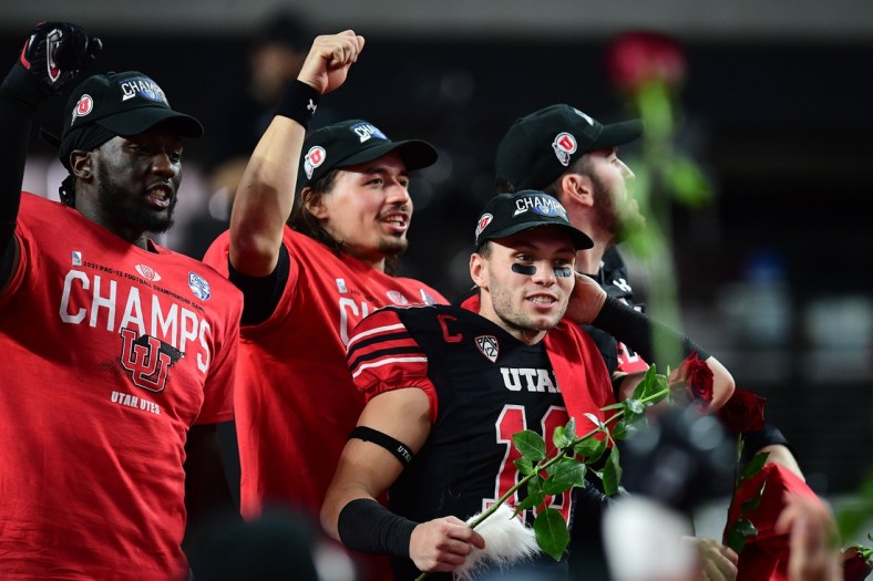 December 3, 2021; Las Vegas, NV, USA; Utah Utes linebacker Devin Lloyd (0) quarterback Cameron Rising (7) and wide receiver Britain Covey (18) celebrate the victory against the Oregon Ducks in the 2021 Pac-12 Championship Game at Allegiant Stadium. Mandatory Credit: Gary A. Vasquez-USA TODAY Sports