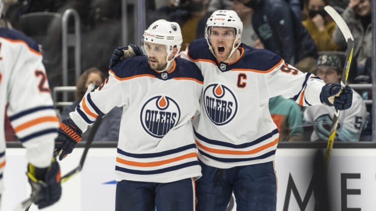Dec 3, 2021; Seattle, Washington, USA;  Edmonton Oilers center Connor McDavid (97) and defenseman Kris Russell (6) celebrate a goal by during the third period at Climate Pledge Arena. Mandatory Credit: Stephen Brashear-USA TODAY Sports