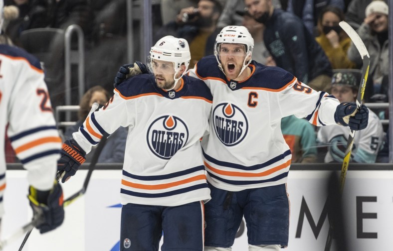 Dec 3, 2021; Seattle, Washington, USA;  Edmonton Oilers center Connor McDavid (97) and defenseman Kris Russell (6) celebrate a goal by during the third period at Climate Pledge Arena. Mandatory Credit: Stephen Brashear-USA TODAY Sports