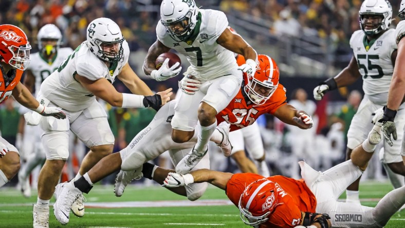 Dec 4, 2021; Arlington, TX, USA; Baylor Bears running back Abram Smith (7) hurdles Oklahoma State Cowboys defensive tackle Israel Antwine (95) during the first half of the Big 12 Conference championship game at AT&T Stadium. Mandatory Credit: Kevin Jairaj-USA TODAY Sports