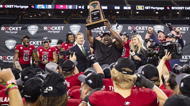 Dec 4, 2021; Detroit, MI, USA; Northern Illinois Huskies head coach Thomas Hammock holds up the trophy with his team after winning the MAC Championship Game against the Kent State Golden Flashes at Ford Field. Mandatory Credit: Raj Mehta-USA TODAY Sports