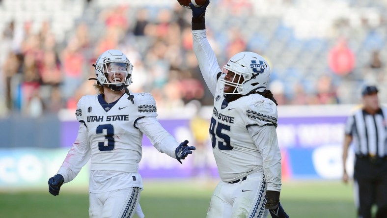 Dec 4, 2021; Carson, CA, USA; Utah State Aggies defensive tackle Marcus Moore (95) and linebacker Justin Rice (3) celebrate the fumble recovery against the San Diego State Aztecs during the second half of the Mountain West Conference championship game at Dignity Health Sports Park. Mandatory Credit: Gary A. Vasquez-USA TODAY Sports