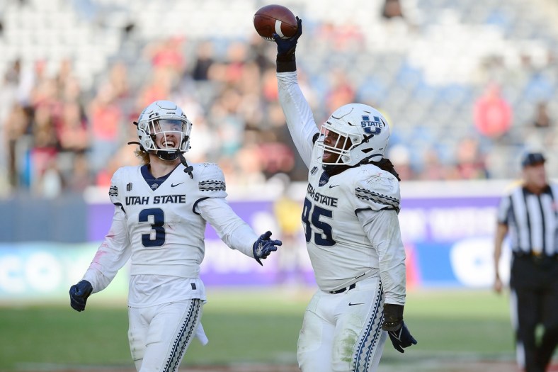 Dec 4, 2021; Carson, CA, USA; Utah State Aggies defensive tackle Marcus Moore (95) and linebacker Justin Rice (3) celebrate the fumble recovery against the San Diego State Aztecs during the second half of the Mountain West Conference championship game at Dignity Health Sports Park. Mandatory Credit: Gary A. Vasquez-USA TODAY Sports