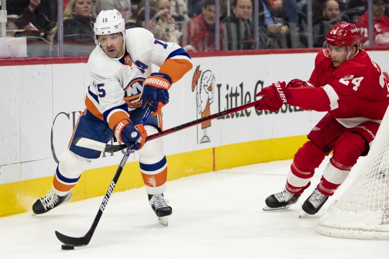 Dec 4, 2021; Detroit, Michigan, USA; New York Islanders right wing Cal Clutterbuck (15) skates with the puck against Detroit Red Wings center Pius Suter (24) during the first period at Little Caesars Arena. Mandatory Credit: Raj Mehta-USA TODAY Sports
