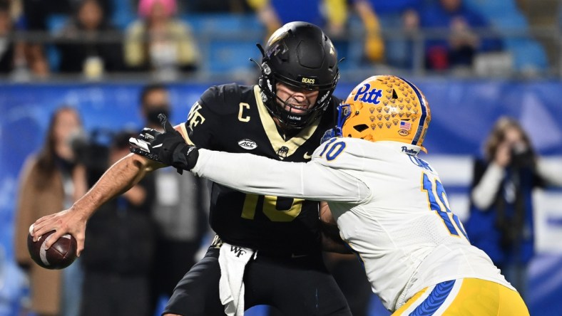 Dec 4, 2021; Charlotte, NC, USA; Wake Forest Demon Deacons quarterback Sam Hartman (10) is sacked by Pittsburgh Panthers defensive lineman Keyshon Camp (10) in the third quarter of the ACC championship game at Bank of America Stadium. Mandatory Credit: Bob Donnan-USA TODAY Sports