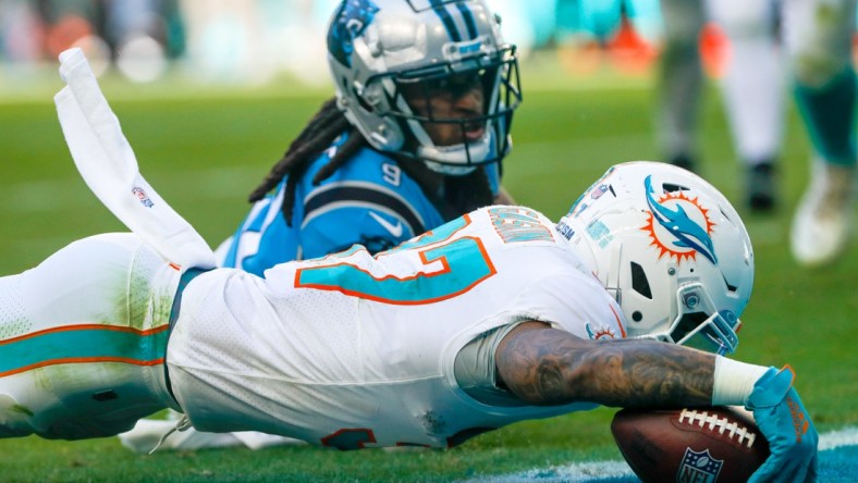 Nov 28, 2021; Miami Gardens, Florida, USA; Miami Dolphins running back Myles Gaskin (37) scores a touchdown against Carolina Panthers cornerback Stephon Gilmore (9) during the second quarter at Hard Rock Stadium. Mandatory Credit: Sam Navarro-USA TODAY Sports