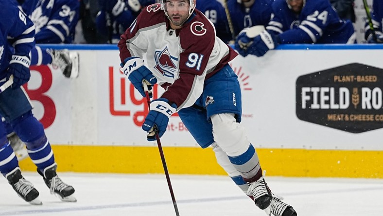 Dec 1, 2021; Toronto, Ontario, CAN; Colorado Avalanche forward Nazem Kadri (91) carries the puck against the Toronto Maple Leafs during the third period at Scotiabank Arena. Mandatory Credit: John E. Sokolowski-USA TODAY Sports