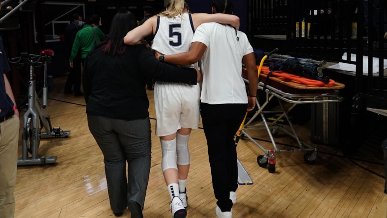 Dec 5, 2021; Storrs, Connecticut, USA; UConn Huskies guard Paige Bueckers (5) is helped off the court after an injury in the second half against the Notre Dame Fighting Irish at Harry A. Gampel Pavilion. Mandatory Credit: David Butler II-USA TODAY Sports