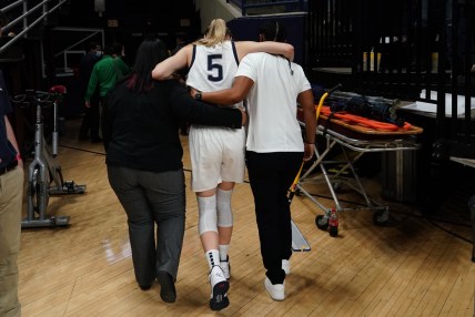 Dec 5, 2021; Storrs, Connecticut, USA; UConn Huskies guard Paige Bueckers (5) is helped off the court after an injury in the second half against the Notre Dame Fighting Irish at Harry A. Gampel Pavilion. Mandatory Credit: David Butler II-USA TODAY Sports