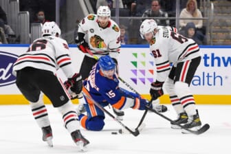 Dec 5, 2021; Elmont, New York, USA;  New York Islanders right wing Cal Clutterbuck (15) attempts to shoot the puck from his knees defended by Chicago Blackhawks defenseman Riley Stillman (61) during the second period at UBS Arena. Mandatory Credit: Dennis Schneidler-USA TODAY Sports