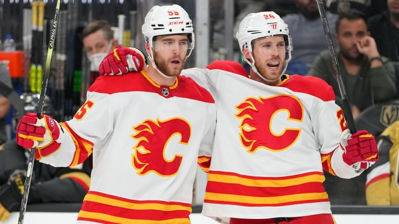 Dec 5, 2021; Las Vegas, Nevada, USA;Calgary Flames center Elias Lindholm (28) celebrates with Calgary Flames defenseman Noah Hanifin (55) after scoring a third period goal against the Vegas Golden Knights at T-Mobile Arena. Mandatory Credit: Stephen R. Sylvanie-USA TODAY Sports