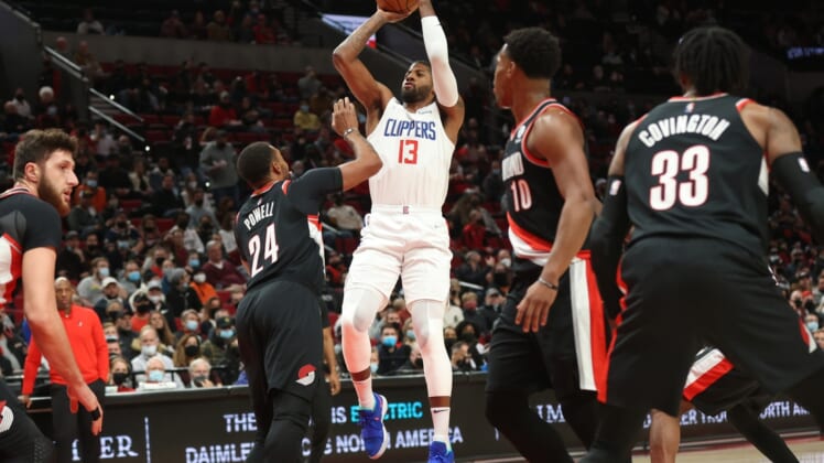 Dec 6, 2021; Portland, Oregon, USA;  LA Clippers guard Paul George (13) shoots over Portland Trail Blazers forward Norman Powell (24) in the first half at Moda Center. Mandatory Credit: Jaime Valdez-USA TODAY Sports