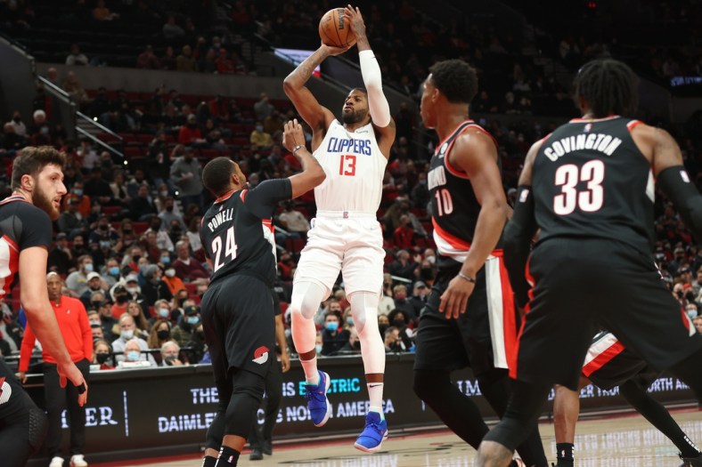 Dec 6, 2021; Portland, Oregon, USA;  LA Clippers guard Paul George (13) shoots over Portland Trail Blazers forward Norman Powell (24) in the first half at Moda Center. Mandatory Credit: Jaime Valdez-USA TODAY Sports