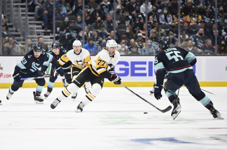 Dec 6, 2021; Seattle, Washington, USA; Pittsburgh Penguins center Jeff Carter (77) advances the puck while being defended by Seattle Kraken defenseman Jeremy Lauzon (55) during the first period at Climate Pledge Arena. Mandatory Credit: Steven Bisig-USA TODAY Sports