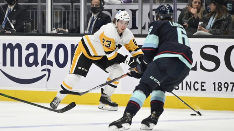 Dec 6, 2021; Seattle, Washington, USA; Pittsburgh Penguins left wing Brock McGinn (23) advances the puck while being defended by Seattle Kraken defenseman Adam Larsson (6)  during the third period at Climate Pledge Arena. Pittsburgh defeated Seattle 6-1. Mandatory Credit: Steven Bisig-USA TODAY Sports