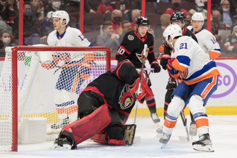 Dec 7, 2021; Ottawa, Ontario, CAN; Ottawa Senators goalie Filip Gustavsson (32) makes a save in front of New York Islanders center Kyle Palmieri (21) in the first period at the Canadian Tire Centre. Mandatory Credit: Marc DesRosiers-USA TODAY Sports