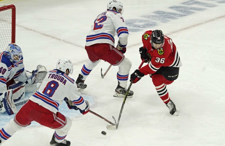 Dec 7, 2021; Chicago, Illinois, USA; Chicago Blackhawks left wing Josiah Slavin (36) and New York Rangers defenseman Jacob Trouba (8) go for the puck during the first period at United Center. Mandatory Credit: David Banks-USA TODAY Sports