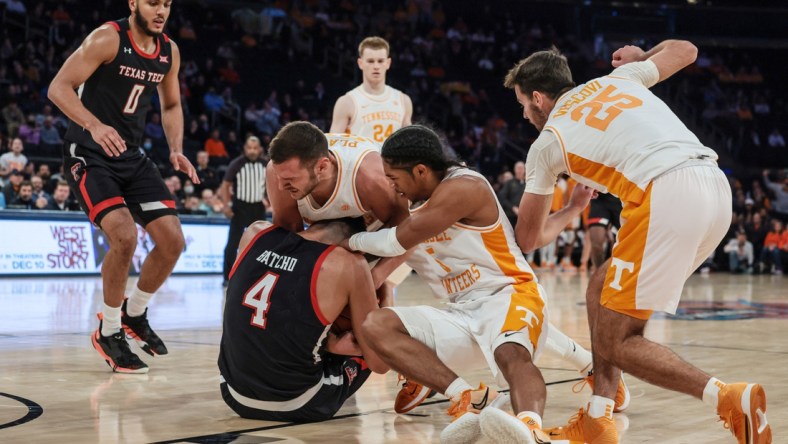 Dec 7, 2021; New York, New York, USA; Texas Tech Red Raiders forward Daniel Batcho (4) battles for a loose ball against Tennessee Volunteers guard Zakai Zeigler (5) and forward Uros Plavsic (33) during the second half at Madison Square Garden. Mandatory Credit: Vincent Carchietta-USA TODAY Sports