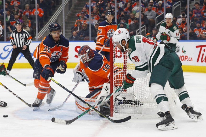 Dec 7, 2021; Edmonton, Alberta, CAN; Minnesota Wild forward Jordan Greenway (18) makes a pass from behind Edmonton Oilers goaltender Mikko Koskinen (19) during the second period at Rogers Place. Mandatory Credit: Perry Nelson-USA TODAY Sports